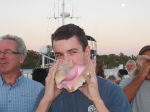 Jackson joins in blowing the conch horn at sunset